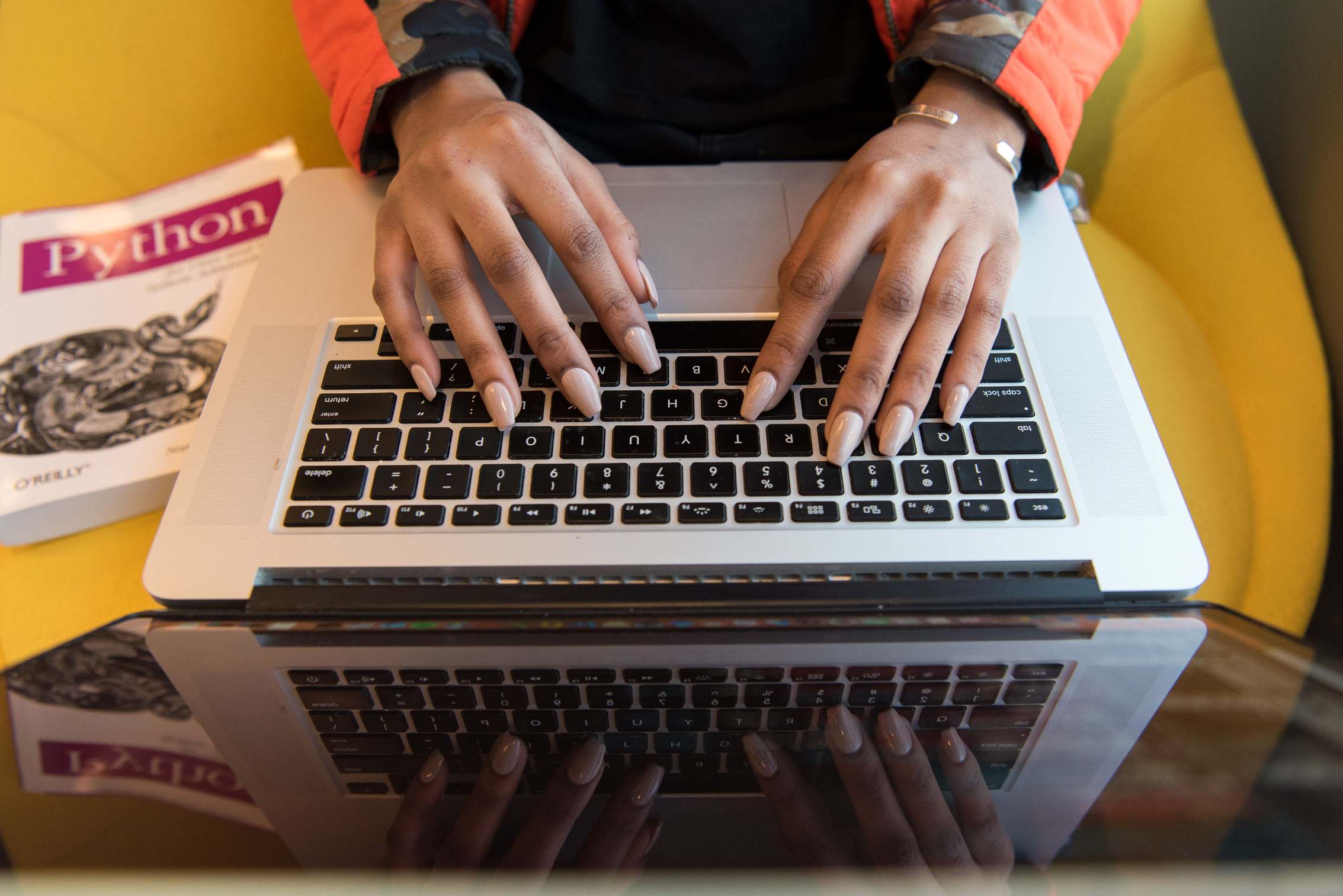 มือของนักพัฒนาที่กำลังเขียนโค้ดบนแล็ปท็อป laptop Python